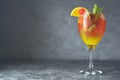 Summer cocktail. Orange juice with mint, syrop, fruit slices and cherry with ice. Dark background Royalty Free Stock Photo