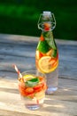 Summer cocktail with strawberry, lemon and mint in glass and bottle on wooden table. Homemade refreshing lemonade, strawberry Royalty Free Stock Photo