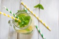 Summer cocktail, water with lemon, ice and mint in mason jar on a white wooden background. Top view. Royalty Free Stock Photo