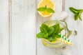 Summer cocktail, water detox with lemon, ice and mint in mason jar on a white wooden background. Top view. Royalty Free Stock Photo