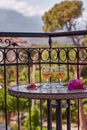 Summer cocktails and surreal pink flowers of bougainvillea in front of mountains and trees. Travel Turkey concept. Romantic dinner