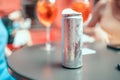 Summer cold aluminum can with alcoholic drink and decor on the table and light bokeh in an outdoor pub