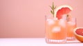 Summer cold cocktail with ice cubes, juice and slices grapefruit on pastel pink background. Generative AI.