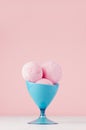 Summer cold dessert - three pink strawberry ice cream balls in elegant blue bowl on white wood table and pastel pink wall. Royalty Free Stock Photo