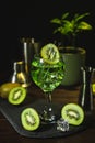 Summer cold drink and beverages. Alcohol coctail with kiwi and ice in wine glass on black background Royalty Free Stock Photo