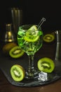 Summer cold drink and beverages. Alcohol coctail with kiwi and ice in wine glass on black background Royalty Free Stock Photo