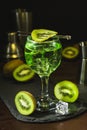 Summer cold drink and beverages. Alcohol coctail with kiwi and ice in wine glass on black background Royalty Free Stock Photo