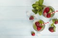 Summer cold drink with strawberry, mint and ice on a light background