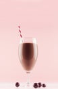 Summer cold fresh milk cocktail of cacao with chocolate candy, straw on white wood board and cute soft pastel pink wall, vertical. Royalty Free Stock Photo