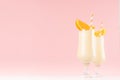 Summer cold fresh milk cocktail of orange with juicy pieces fruit, straws on white wood board and cute soft pastel pink wall. Royalty Free Stock Photo
