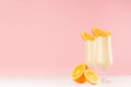 Summer cold fresh milk cocktail of orange with juicy pieces fruit on white wood board and cute soft pastel pink wall, copy space. Royalty Free Stock Photo