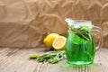 Summer cold green drink made from tarragon, with mint and slices lemon in glass decanter in focus and green estragon Royalty Free Stock Photo
