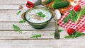 Summer cold kefir soup in glass bowl with spicy herbs