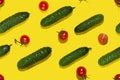 Summer color food seamless pattern - red cherry tomatoes and green gherkin cucumber in sunlight with shadows on yellow backdrop. Royalty Free Stock Photo