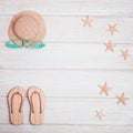 Summer composition, beach slippers, straw yellow hat, starfish, sunglasses on white wood, summer background Royalty Free Stock Photo