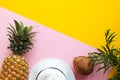 Summer composition. Coconut, pineapple, palm tree leaves and hat on a pink-yellow background with copy spase. Summertime, vacation