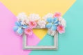 Summer composition. Empty frame and flowers flat lay on yellow, green and pink pastel background with copy space