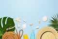 Summer composition flat lay. Round trendy rattan bag straw hat tropical palm leaves coconut sunscreen seashells on blue background Royalty Free Stock Photo