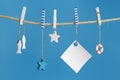 Summer composition with marine items hanging on string with blue. Sea toys lifeline, seastars and small fish Royalty Free Stock Photo