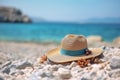 Summer composition on sandy beach with hat at blue sea as background. Summer vacation concept Royalty Free Stock Photo