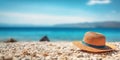 Summer composition on sandy beach with hat at blue sea as background. Summer vacation concept Royalty Free Stock Photo