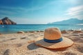 Summer composition on sandy beach with hat at blue sea as background. Summer vacation concept Royalty Free Stock Photo