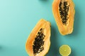 Summer composition. Tropical lime and papaya fruit cut in half lie on a blue background. Summer concept. Flat lay, top view Royalty Free Stock Photo