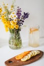 Summer concept. Bouquet of wild natural flowers. Homemade lemonade with orange and lemon. Healthy  fresh cool beverage Royalty Free Stock Photo