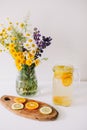 Summer concept. Bouquet of wild natural flowers. Homemade lemonade with orange and lemon. Healthy  fresh cool beverage Royalty Free Stock Photo