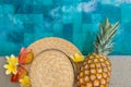 Summer concept. Hat, glasses, pineapple, flowers by the pool.