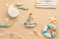 Summer concept. Ship,  ammonite, starfishes,snail shell, fishes and lifebuoy on sand. Top view. Copy space Royalty Free Stock Photo