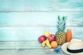 Summer concept stillife - a pile of fresh fruits, straw hat and a bottle of multivitamin juice in front of a blue rustic wooden Royalty Free Stock Photo