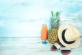 Summer concept stillife - ripe pineapple, straw hat, flip-flops and a bottle of multivitamin juice in front of a blue rustic Royalty Free Stock Photo