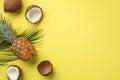 Summer concept. Top view photo of tropical fruits pineapple cracked coconuts and green palm leaves on isolated yellow background Royalty Free Stock Photo