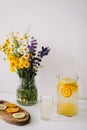 Summer concept. Bouquet of wild natural flowers. Homemade lemonade with orange and lemon. Healthy  fresh cool beverage Royalty Free Stock Photo