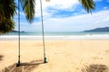 Summer concept. Wood swing hanging from coconut palm tree over beach sea. Asia Thailand. with copy space for text or design Royalty Free Stock Photo