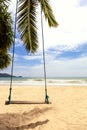Summer concept. Wood swing hanging from coconut palm tree over beach sea. Asia Thailand. with copy space for text or design Royalty Free Stock Photo