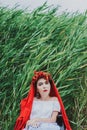 Summer conceptual portrait of beautiful young caucasian woman with red lips, red flowers in hair, sitting in wheel chair. frame wi