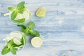 Summer cool lemonade in two wet glasses with mint, lime, ice, straw on soft shabby blue wood board, copy space, top view. Royalty Free Stock Photo