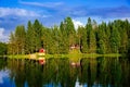 Summer cottage or log cabin by the blue lake in rural Finland. Royalty Free Stock Photo