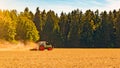 Summer countryside / agriculture harvest forest background banner panorama: old tractor milling straw grain barley wheat field, Royalty Free Stock Photo