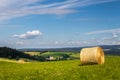 summer landscape with a field with hay bale and blue sky with white clouds Royalty Free Stock Photo