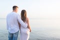 Summer couple embracing at sunset on beach. Romantic young couple enjoying sun