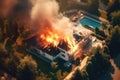 On a summer day, an aerial view captures the sight of a fire engulfing a modern villa. The flames dance and consume the