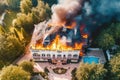 On a summer day, an aerial view captures the sight of a fire engulfing a modern villa. The flames dance and consume the