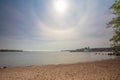 On a summer day, the beach on the Gulf of Finland. A halo around the sun