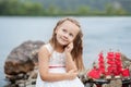 Summer day. Happy childhood carefree game on the open sand. The concept of rest. Little cute girl and scarlet sails. Girl sitting Royalty Free Stock Photo