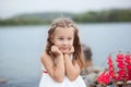 Summer day. Happy childhood carefree game on the open sand. The concept of rest. Little cute girl and scarlet sails. Girl sitting Royalty Free Stock Photo