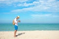 Summer Day. Happy smiling caucasian tourist asian young man holding camera for take a photo check in on the beach. Royalty Free Stock Photo