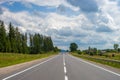 Summer day landscape with forest, cloudy sky and road. Royalty Free Stock Photo